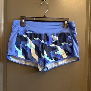 Nike Dri-FIT running shorts in a blue and white geometric pattern.